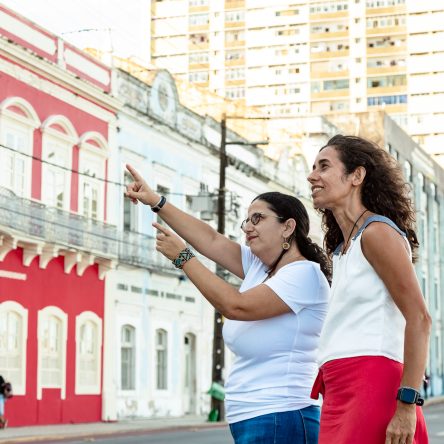 Fotografia de duas mulheres observando os casarões coloridos da Rua da Aurora.