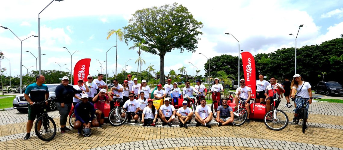 Fotografia com 29 pessoas posando, ao fundo uma praça com árvores.